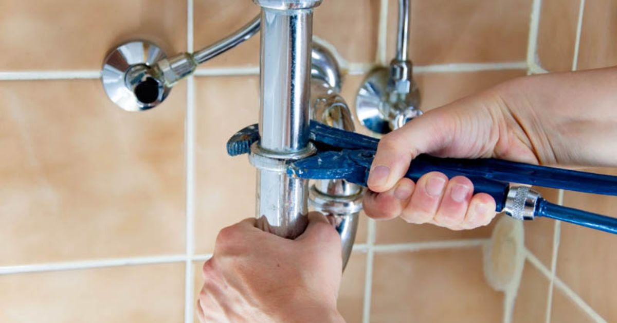 A plumber removing a shower with a tool